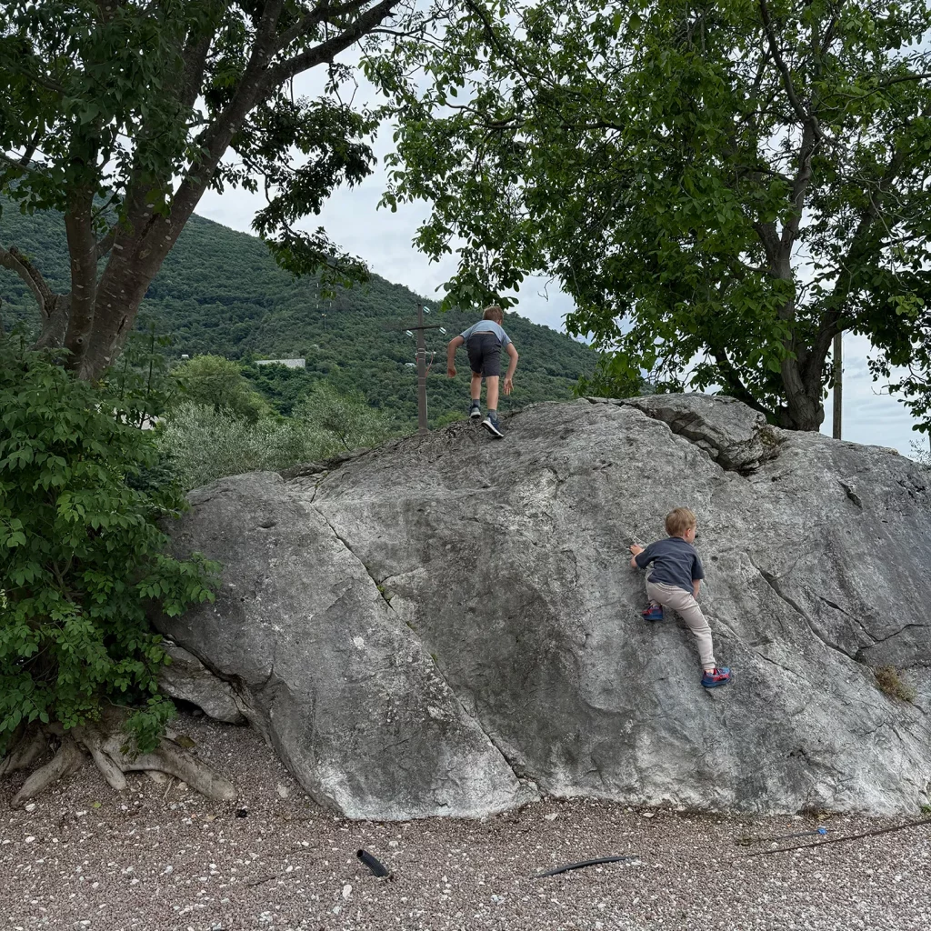 Kinder klettern auf einen kleinen Felsen auf dem Agricamping Agrisalus am Gardasee.